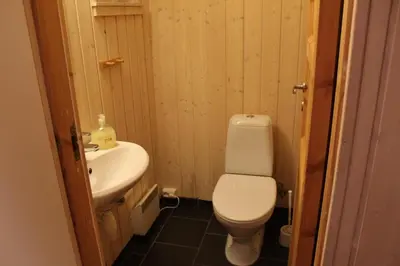a bathroom with a white toilet and a sink at Gålå Fjellhytte - cabin with sauna and whirlpool tub in Sør-Fron