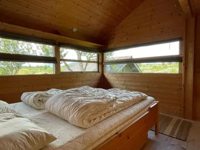 a bedroom with two beds in a wooden cabin at Svarthamar - cabin with amazing view in Ål