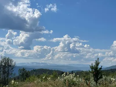 a blue sky with clouds and mountains in the distance at Svarthamar - cabin with amazing view in Ål