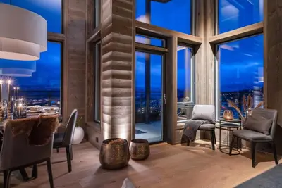a dining room with a view of the city at night at Riddertunets top notch in Beitostøl