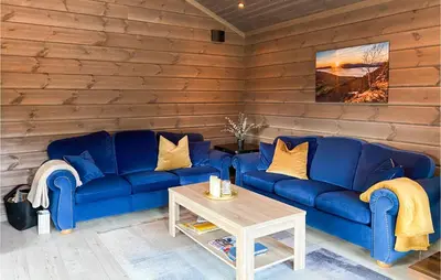 a living room with blue couches and a coffee table at 4 Bedroom Amazing Home In Stryn in Stryn