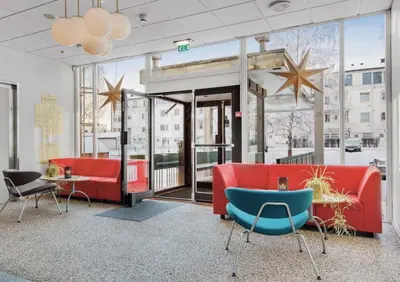 a lobby with red and blue furniture and large windows at Gjøvik Overnatting in Gjøvik