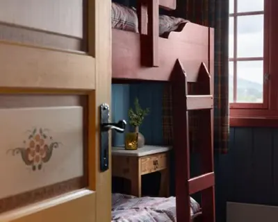 a room with a bunk bed with a desk and a bed sidx sidx at Vestlia Ski in Geilo