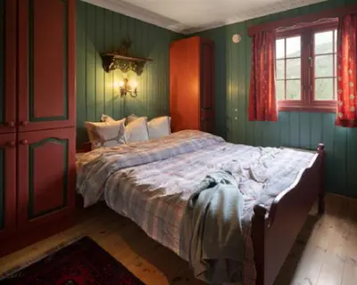 a bedroom with a large bed with green walls at Vestlia Ski in Geilo