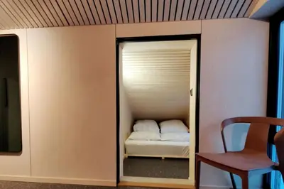 a small room with a small bed in a room at Huset ved skogen in Isfjorden