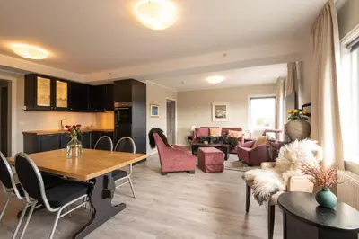 a living room with a table and a dining room at Skåbu Fjellhotell in Skåbu