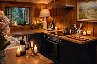 a kitchen with candles on a counter and a stove at Traditional timber farm with Sauna & Wi-Fi in Baukål