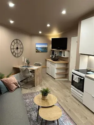 a living room with a couch and a kitchen at Gjestehus i Sogndal med utsikt over fjord og fjell in Sogndal