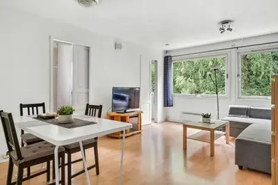 a living room with a table and a couch at Fully equipped independent apartment near NTNU,Lerkendal og center in Trondheim