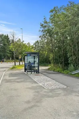 a bus stop on the side of a road at Fully equipped independent apartment near NTNU,Lerkendal og center in Trondheim