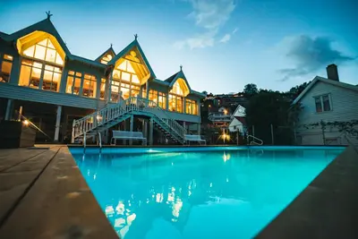 a large house with a swimming pool at night at Hofslund Apartments in Sogndal