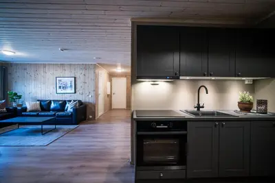 a kitchen with black cabinets and a living room at Bjorli Fjellstuer - by Classic Norway Hotels in Bjorli