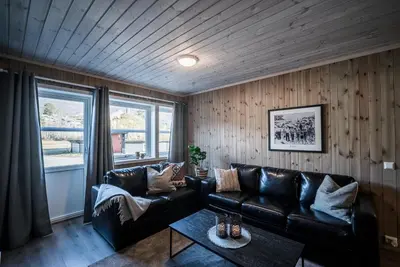 a living room with a leather couch and a table at Bjorli Fjellstuer - by Classic Norway Hotels in Bjorli