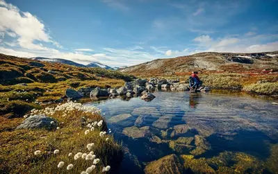 a person is standing in a stream in a field at Bjorli Fjellstuer - by Classic Norway Hotels in Bjorli