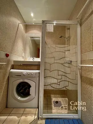 a washing machine in a bathroom with a shower at Cozy apartment with a view and ski inout Hafjell in Hafjell