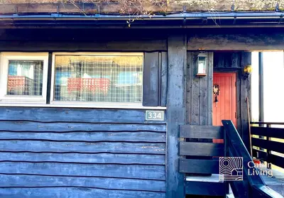 a blue house with a red door and a window at Cozy apartment with a view and ski inout Hafjell in Hafjell
