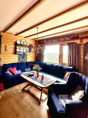 a living room with a blue couch and a table at Cozy apartment with a view and ski inout Hafjell in Hafjell