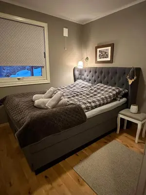 a large bed in a bedroom with a window at Hyggelig leilighet i sentrum in Hemsedal