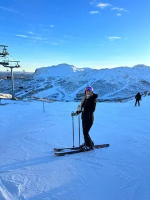 a woman is standing on skis in the snow at Hyggelig leilighet i sentrum in Hemsedal