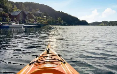an orange kayak in the water near a dock at 3 Bedroom Lovely Home In Hebnes in Hebnes