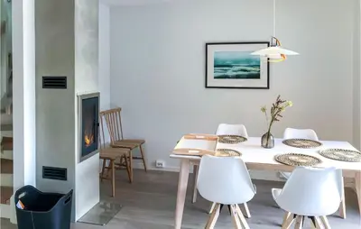 a dining room with a table and chairs and a fireplace at 3 Bedroom Lovely Home In Hebnes in Hebnes