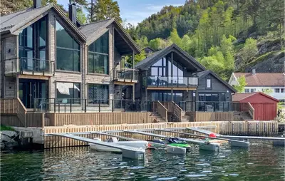 a house on the water with boats in the water at Amazing Home In Hebnes With Wifi in Hebnes