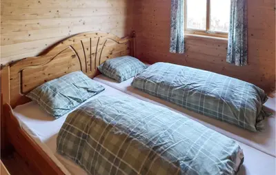 two beds in a log cabin with a window at 4 Bedroom Stunning Home In Auklandshamn in Tjernagel