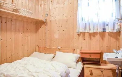 a bedroom with a bed and a sink in it at 4 Bedroom Lovely Home In Nordtveitgrend in Hjartåker
