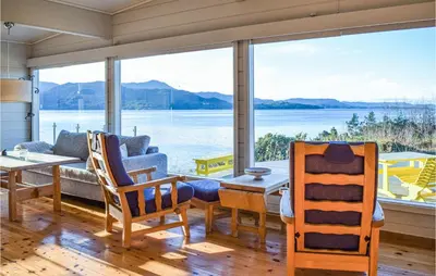 a living room with a view of the water at 4 Bedroom Lovely Home In Nordtveitgrend in Hjartåker