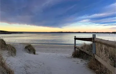 a fence on a beach near the water at Cozy Home In Vevang With Sauna in Vevang