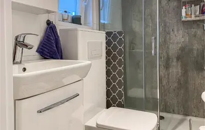 a bathroom with a toilet and a sink and a shower at Lovely Home In Smøla With Kitchen in Smøla