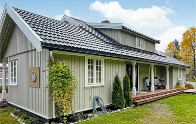 a green house with a porch and a yard at Lovely Home In Bjoneroa With Wifi in Bjoneroa