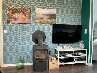 a living room with a stove in front of a tv at 6 person holiday home in Huglo-By Traum in Nordhuglo