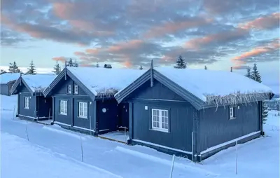 a building with snow on top of it in the snow at Beautiful Home In Sjusjøen With Wifi in Sjusjøen