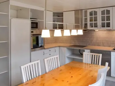 a kitchen with white cabinets and a wooden table and chairs at 8 person holiday home in Snillfjord-By Traum in Snillfjord