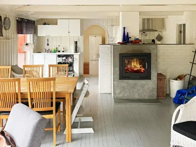 a living room with a table and a fireplace at 9 person holiday home in Mosvik-By Traum in Mosvik