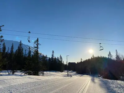 a ski lift handing over a snow covered road at Astonishing Mountain Lodge at the top of Gaustablikk, 25m2 west facing terrace, 3 bedrooms in Gaustablikk