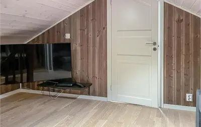 an empty room with a door and wooden walls at 3 Bedroom Gorgeous Home In Brøttum