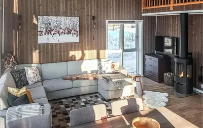 a living room with a couch and a tv at 3 Bedroom Gorgeous Home In Brøttum