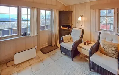 a living room with two chairs and a table and windows at Awesome Home In Hemsedal With Wifi in Hemsedal