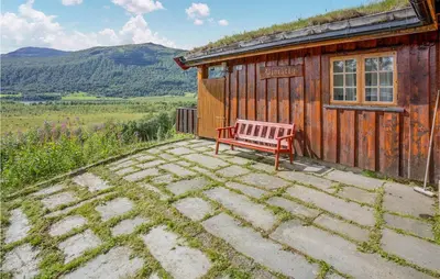 a red bench sitting in front of a cabin at Awesome Home In Hemsedal With Wifi in Hemsedal