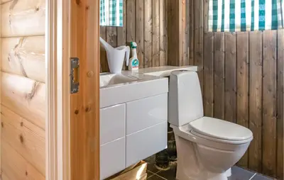 a bathroom with a toilet and a sink at 3 Bedroom Nice Home In Oppdal in Oppdal