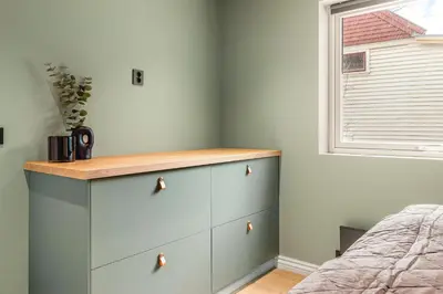 a bedroom with a blue chest of drawers and a window at Odda View - 4BR & 2BR & 1BR - B11 in Odda