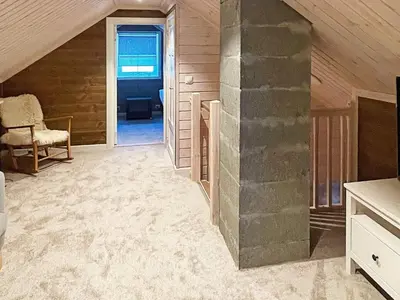 an attic room with a stone pillar and a chair at 7 person holiday home in Rauland-By Traum in Rauland