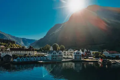 a town on the water with a mountain in the background at Wangen Apartments in Aurland