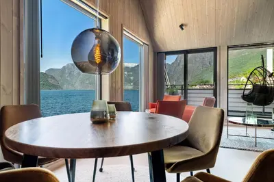 a dining room with a table and chairs and a large window at Wangen Apartments in Aurland
