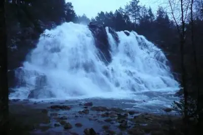 a waterfall in the middle of a river at Small Basement Apartment Private Entrance Nice View in Fitjar