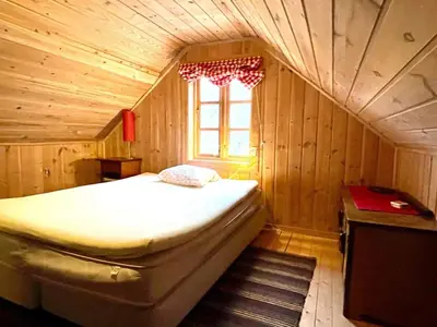a bedroom with a bed in a wooden room at 8 person holiday home in Åkra-By Traum in Åkra