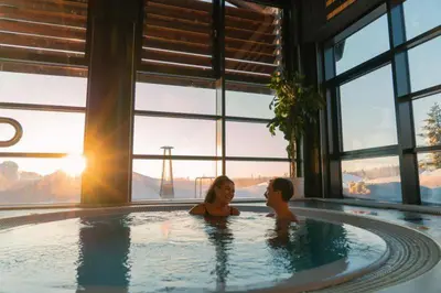 a man and woman sitting in a hot tub with the sun at Skogro ved Norefjell in Noresund