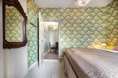 a bedroom with a bed and floral wallpaper at Jugend 1905 in Ålesund